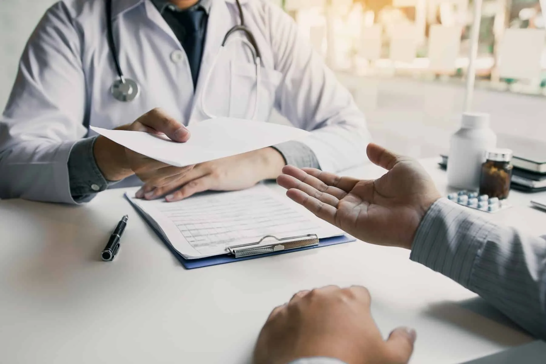 Clinician handing credentialing paperwork to a colleague